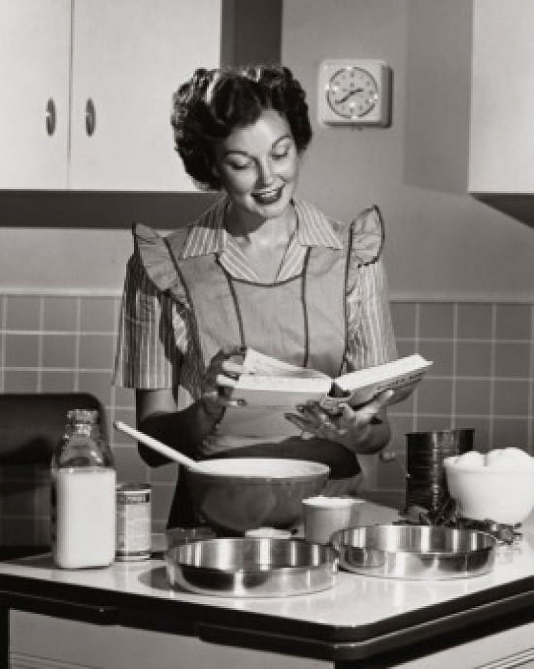 Mid adult woman reading a cookbook and smiling Canvas Art - (24 x 36)