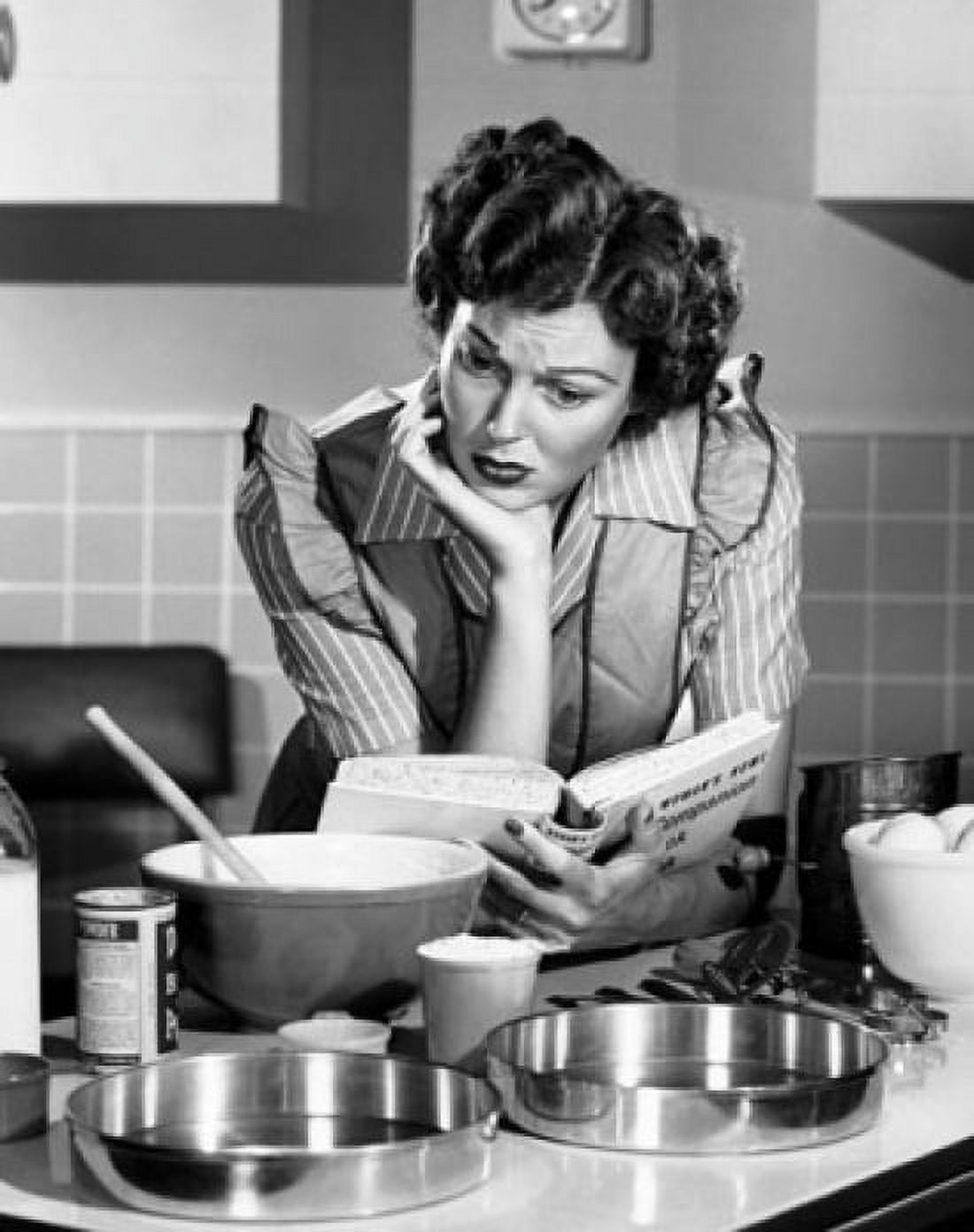 Mid adult woman reading a cookbook in a domestic kitchen Canvas Art - (24 x 36)