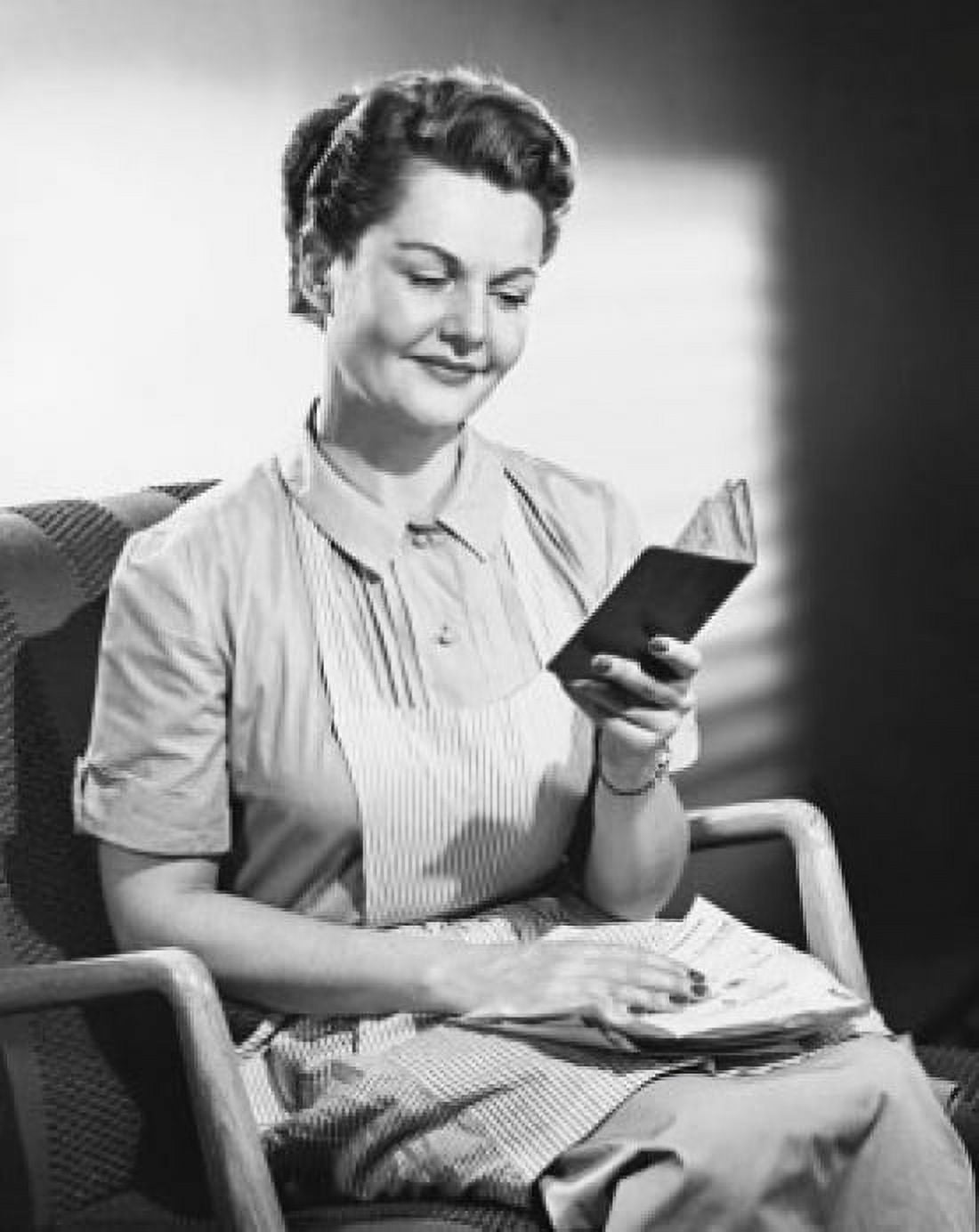 Mid adult woman sitting in an armchair and holding a passport Canvas Art - (18 x 24)