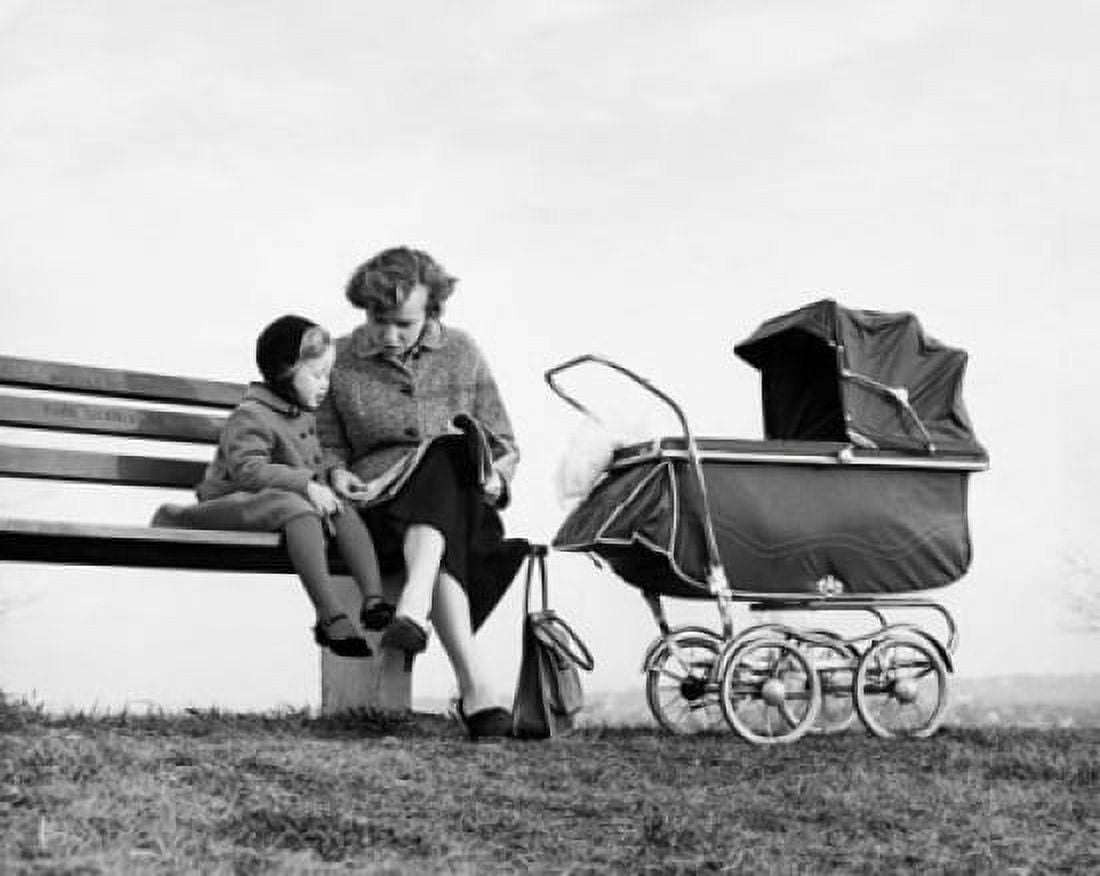 Mid adult woman sitting with her daughter on a bench and reading a magazine Canvas Art - (18 x 24)