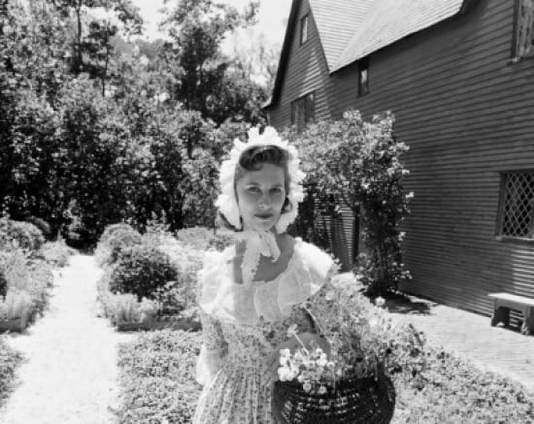 Mid adult woman wearing bonnet standing in summer garden Canvas Art - (24 x 36)