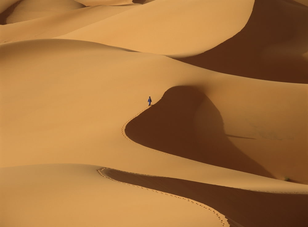 Morocco Berber blue man walking through sand dunes in Erg Chebbi area Sahara Desert near Merzouga Canvas Art - Ian Cumming Design Pics (18 x 13)