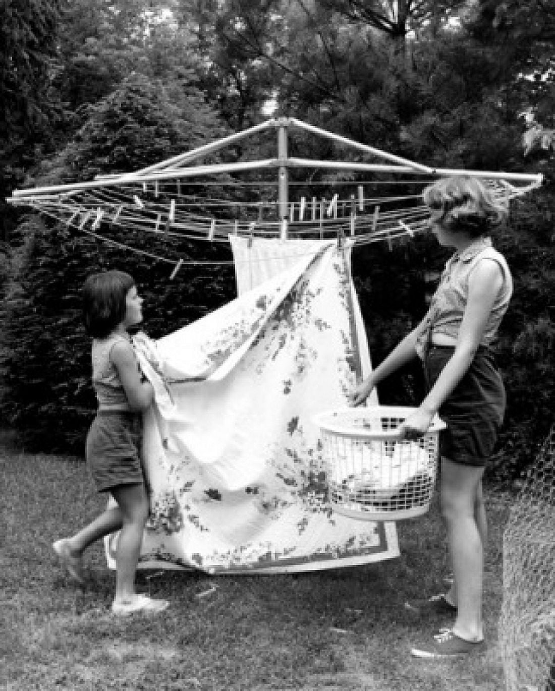 Mother and daughter hanging laundry in backyard Canvas Art - (18 x 24)