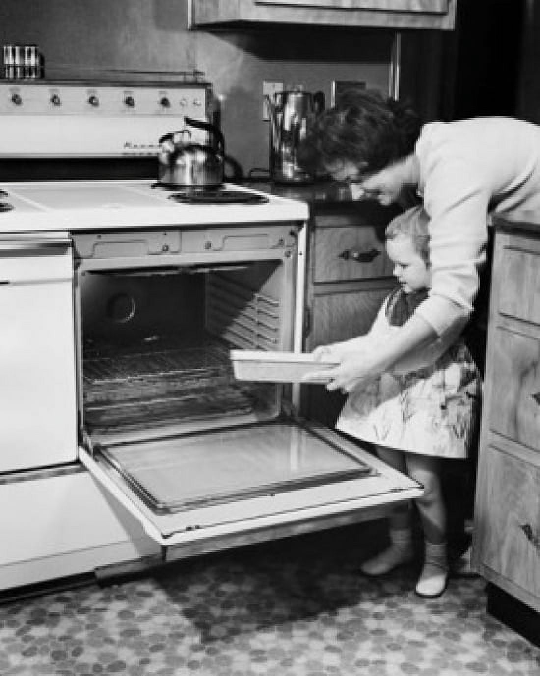 Mother and her daughter putting a pan in the oven Canvas Art - (18 x 24)