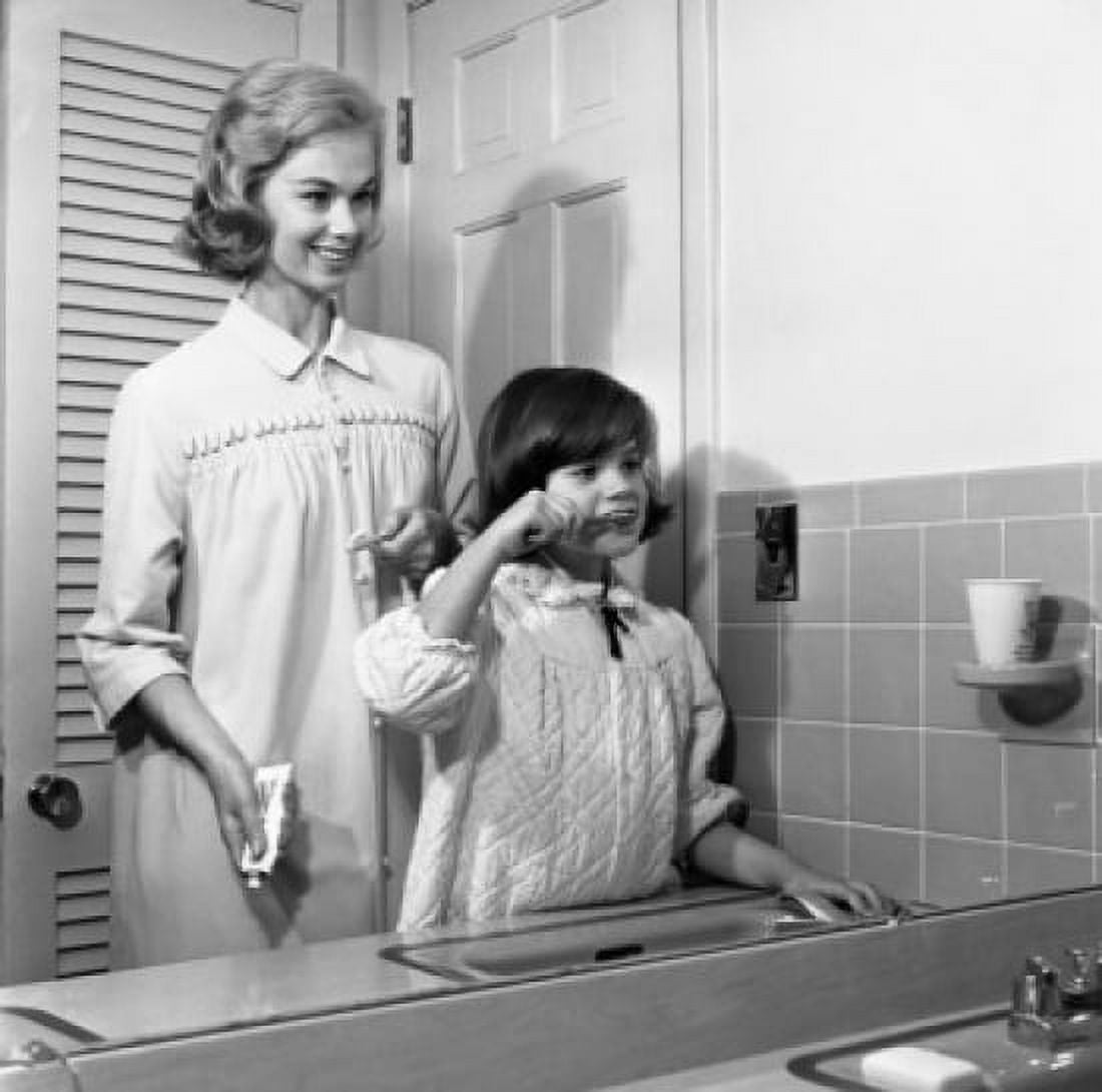 Mother assisting daughter with brushing teeth reflecting in mirror Canvas Art - (18 x 24)