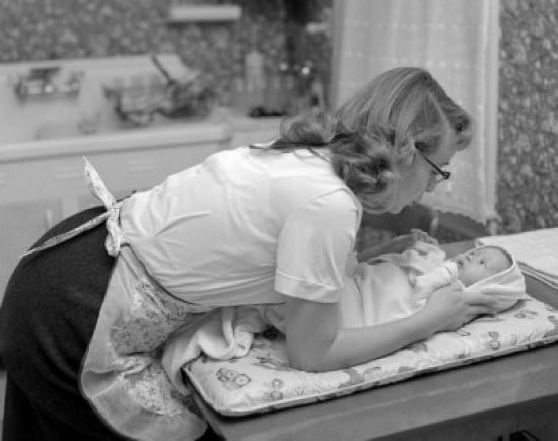 Mother bending over baby lying on changing mat Canvas Art - (18 x 24)