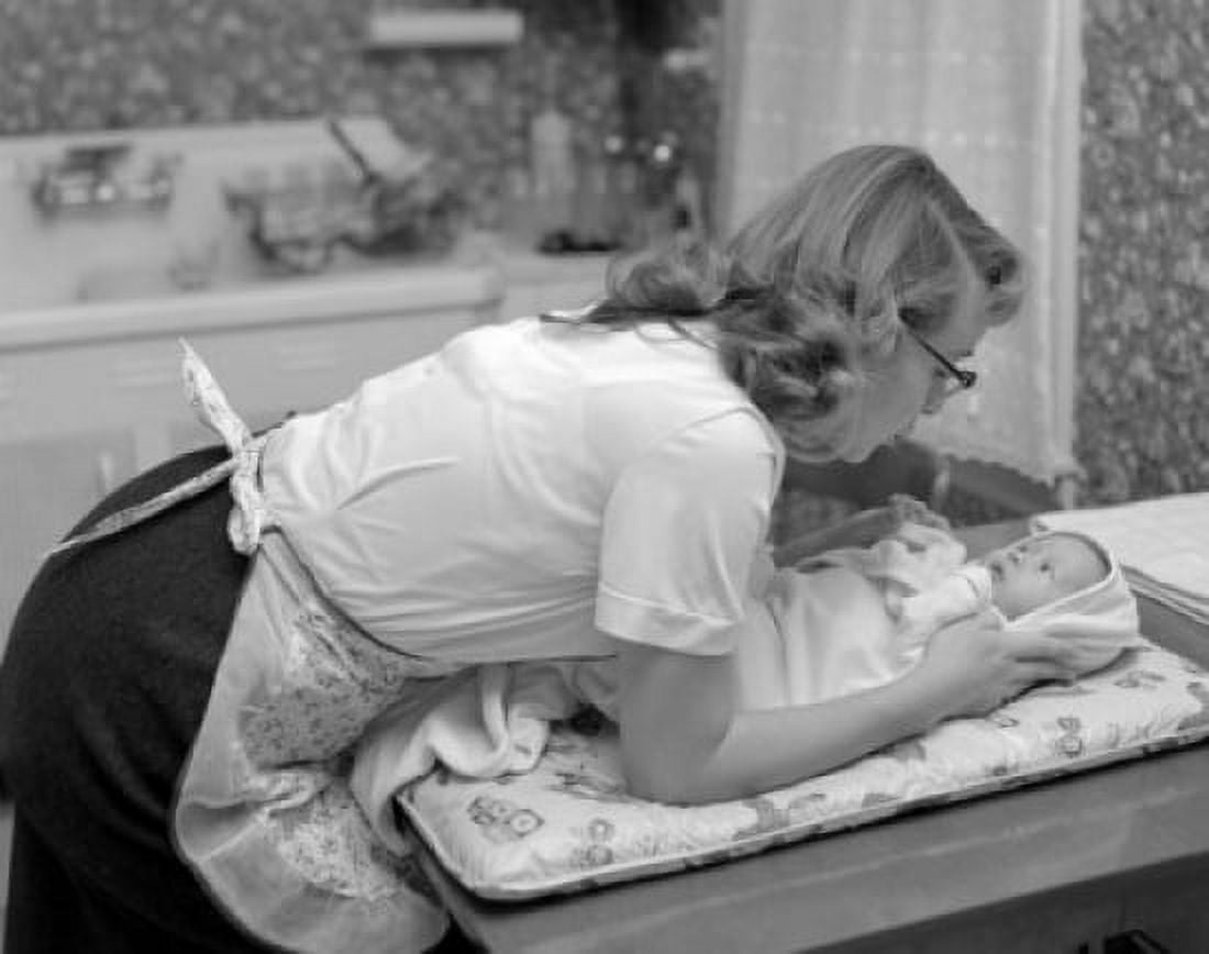 Mother bending over baby lying on changing mat Canvas Art - (24 x 36)