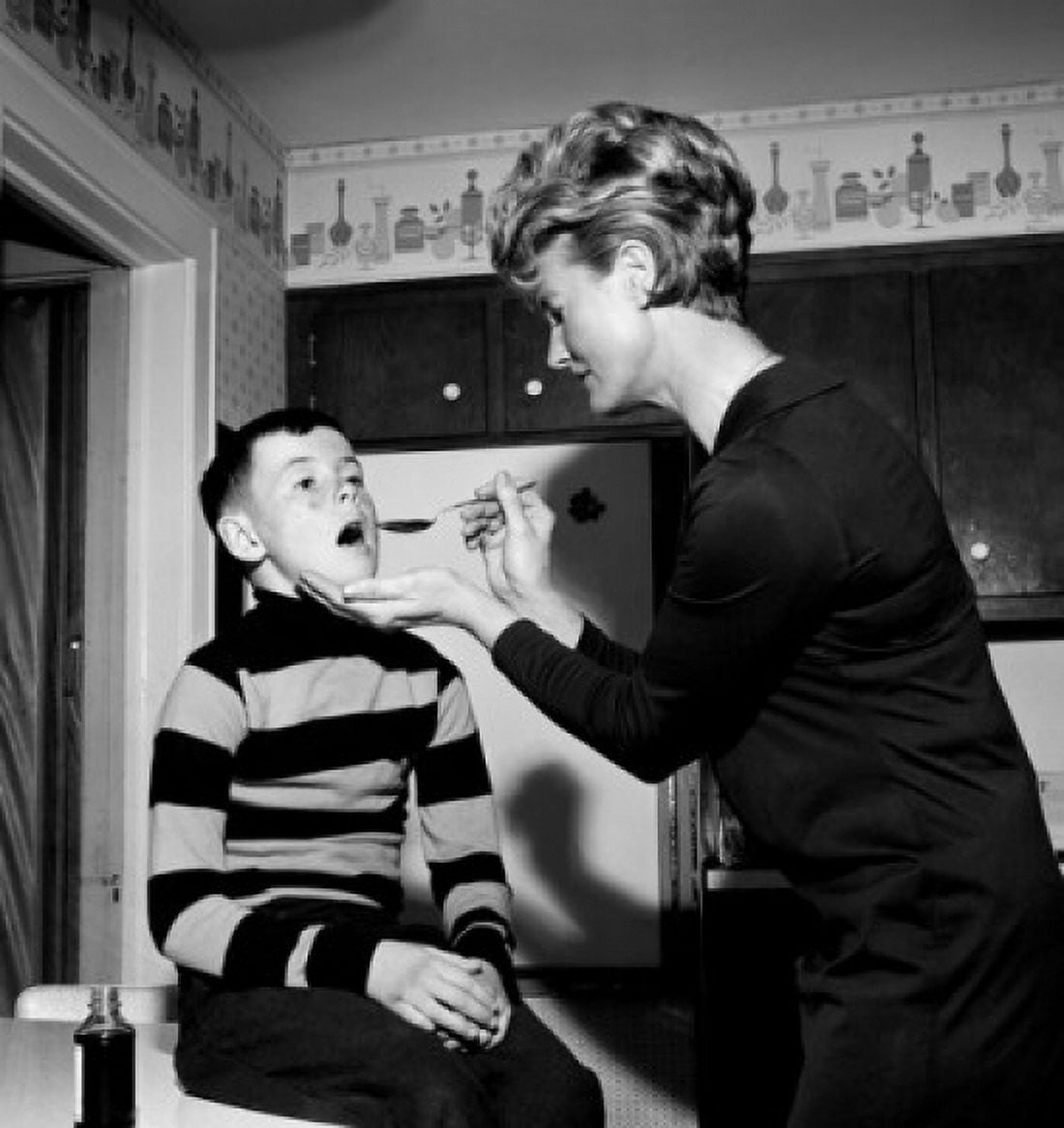 Mother serving medicine to son Canvas Art - (24 x 36)