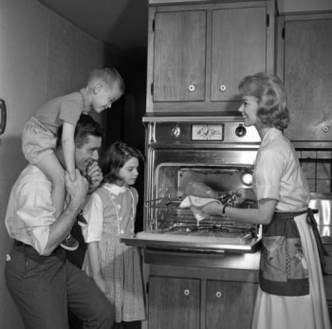 Mother showing freshly baked chicken to husband and children Canvas Art - (18 x 24)
