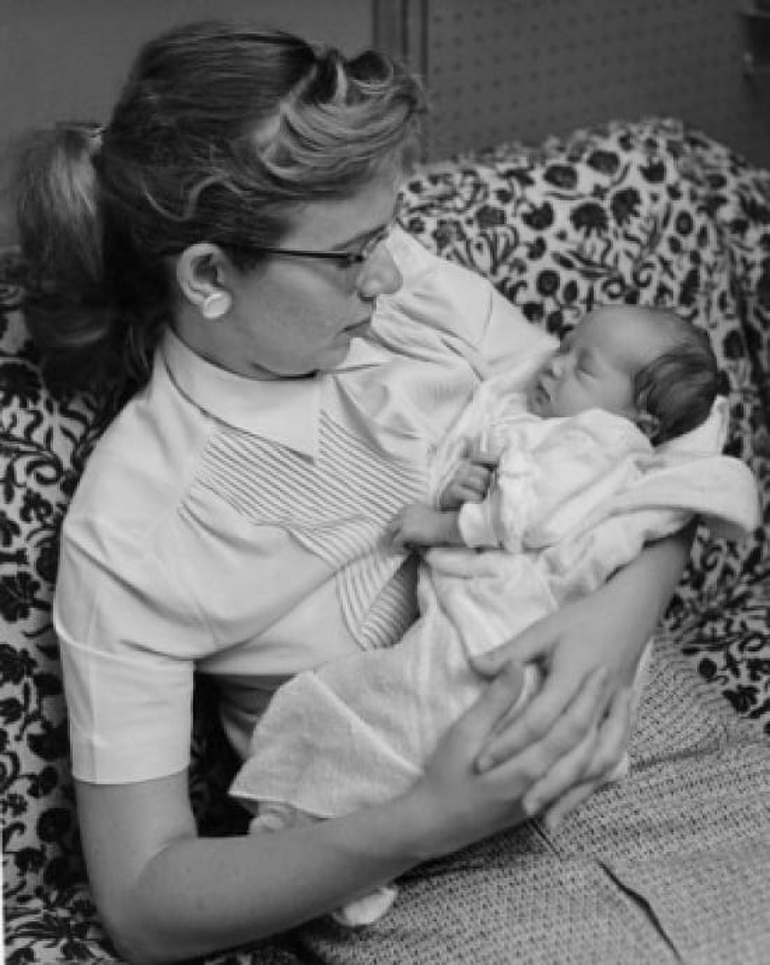 Mother sitting on sofa with sleeping baby in arms Canvas Art - (24 x 36)