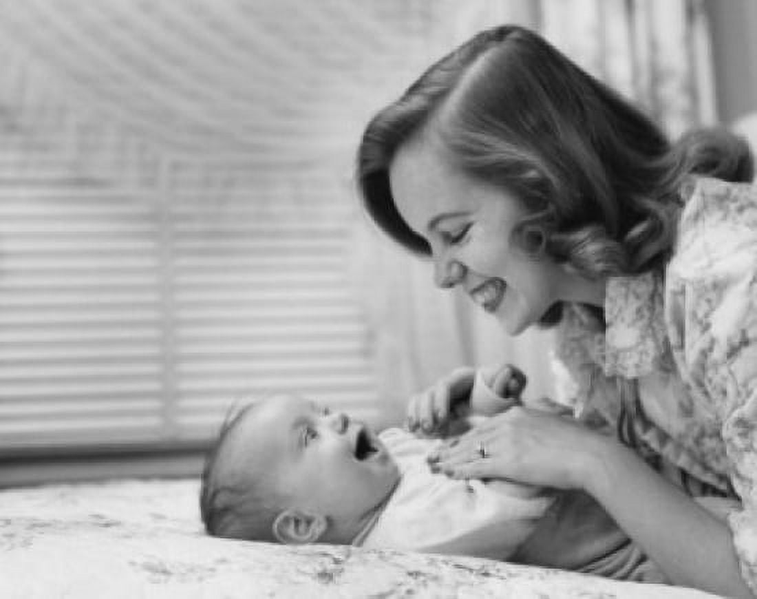 Mother with baby lying on bed and laughing Canvas Art - (24 x 36)