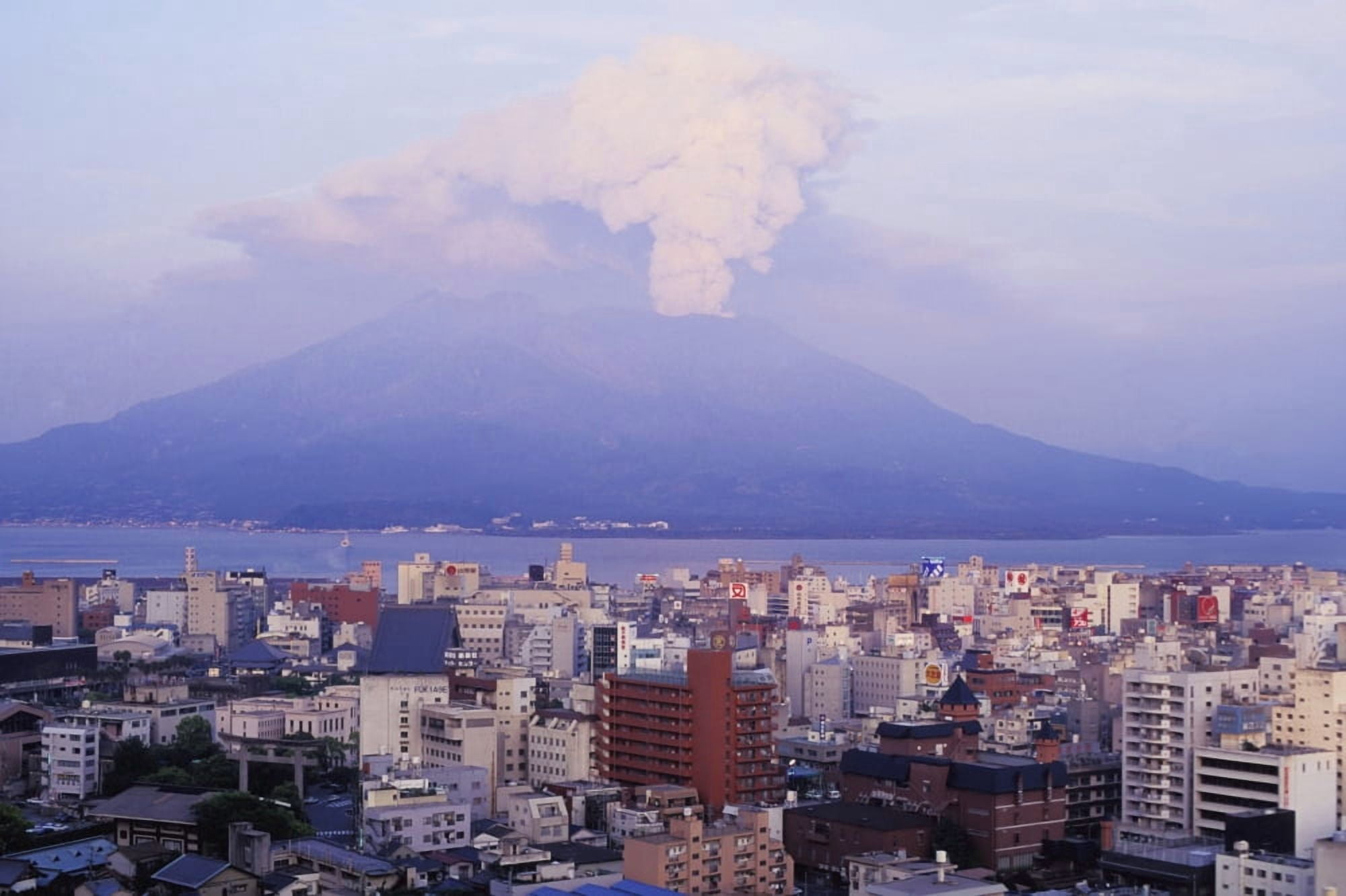 Mount Sakurajima Erupting In Front Of Skyline Canvas Art - Jim Holmes Design Pics (19 x 12)