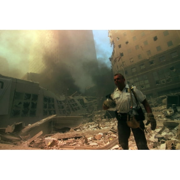 New York City Policeman In Ruins Following September 11Th Terrorist Attack On World Trade Center. He Stands In The Rubble With The North Pedestrian Bridge Over West Side Highway (West St.). In The