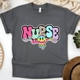 thumbnail image 1 of Nurse Graphic T-Shirt with Retro Pastel Letters and Smiley Design, Dark Heather, Size M, 1 of 6