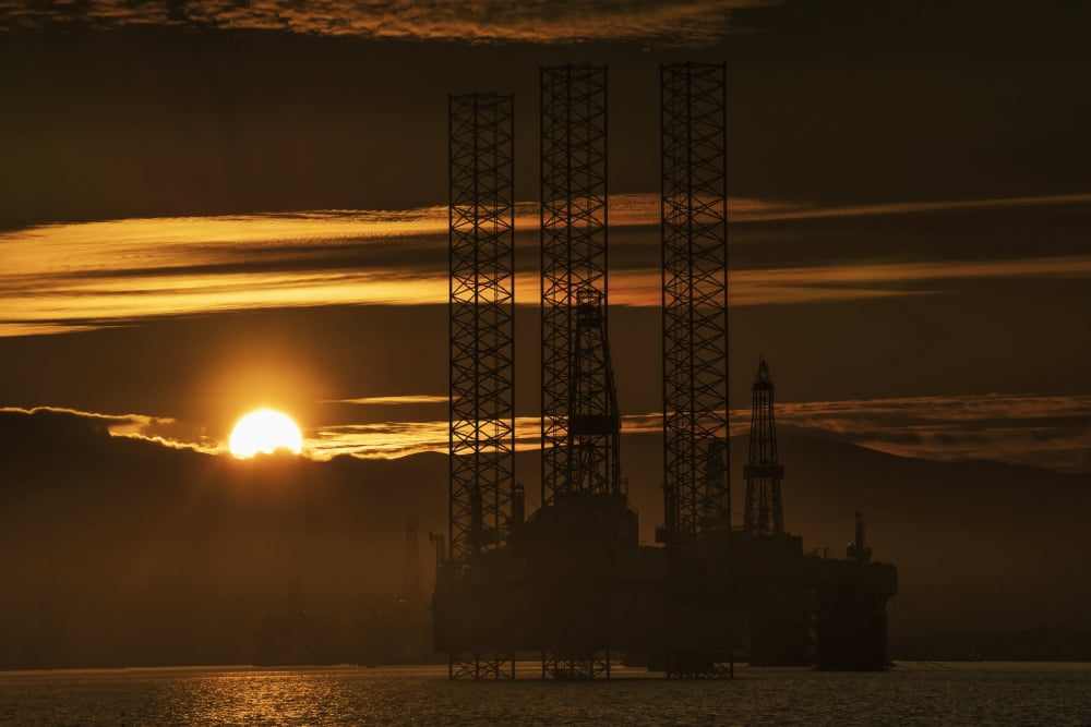 Oil drilling rigs out in the ocean with a view of the coastline and golden sunset Cromarty Invergordon Scotland Canvas Art - John Short Design Pics (19 x 12)