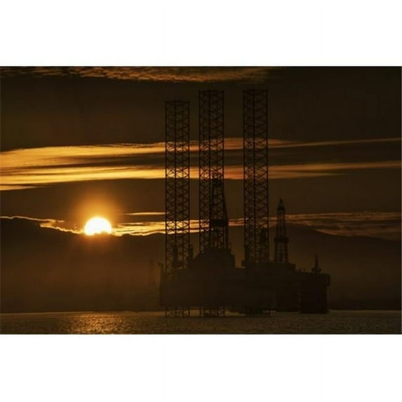 Oil drilling rigs out in the ocean with a view of the coastline and golden sunset; Cromarty Invergordon Scotland 19 x 12