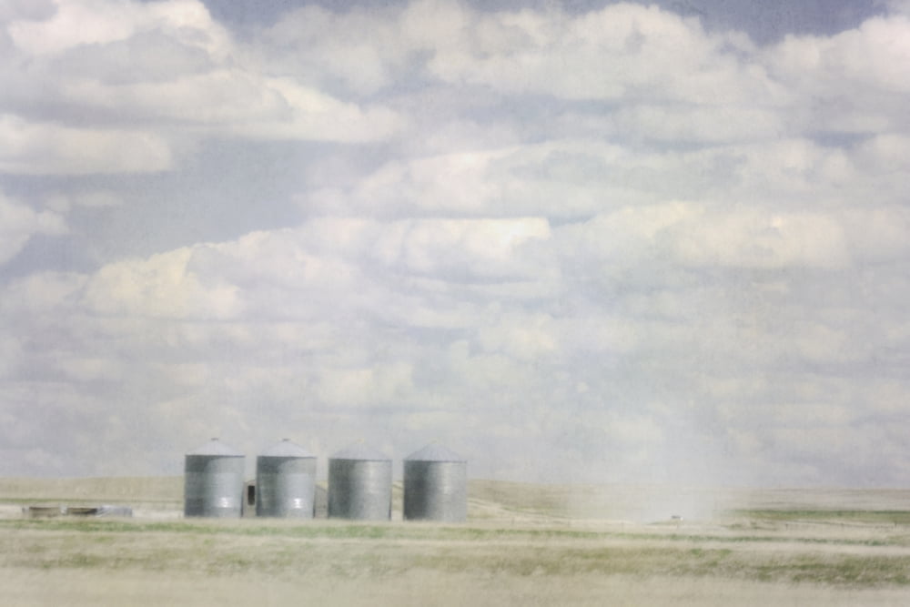 Painterly photo of grains bins and the dust of a truck on a gravel road in the prairies Alberta Canada Canvas Art - Roberta Murray  Design Pics (38 x 24)
