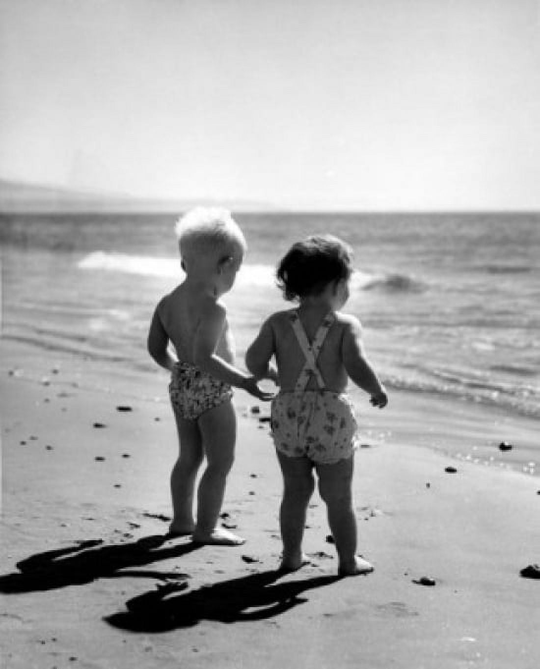 Pair of children wearing swimming costumes on beach watching surf Canvas Art - (18 x 24)