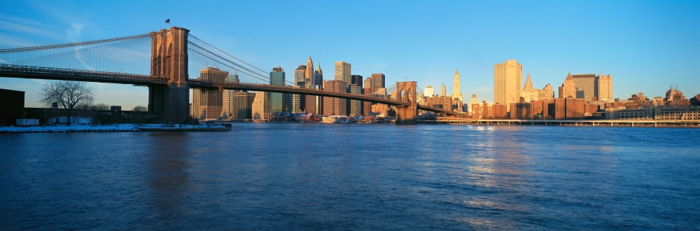 Panoramic view of Brooklyn Bridge and East River at sunrise with New York City where World Trade Towers were located NY Canvas Art - Panoramic Images (27 x 9)