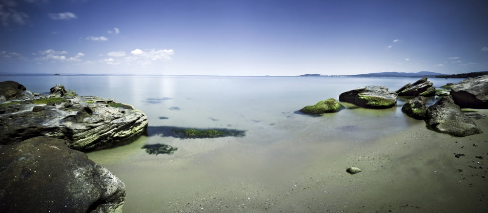 Panoramic view of tranquil sea and boulders against blue sky Burgas Bulgaria Canvas Art - Evgeny KuklevStocktrek Images (43 x 19)