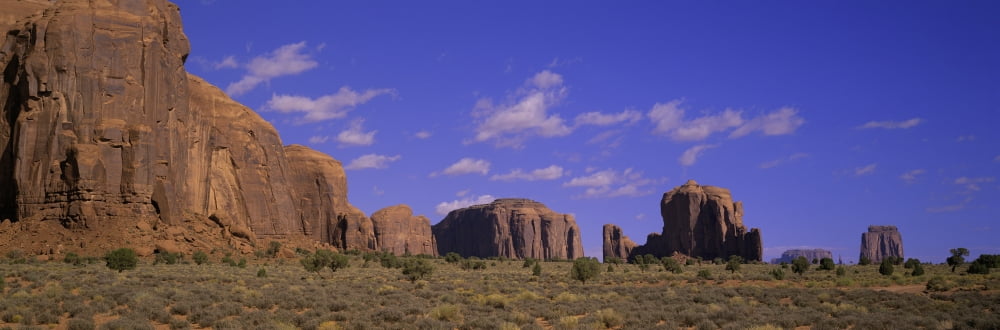 Panoramic view of red buttes and colorful spires of Monument Valley Navajo Tribal Park Southern Utah near Arizona border Canvas Art - Panoramic Images (27 x 9)