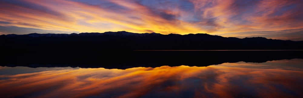 Panoramic view at sunset of flooded salt flats and Panamint Range Mountains in Death Valley National Park California Canvas Art - Panoramic Images (27 x 9)