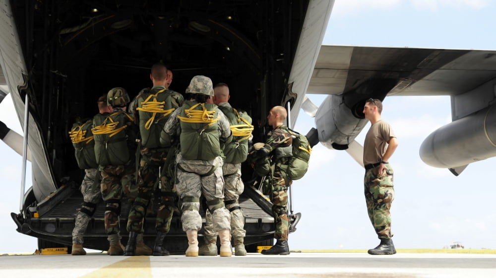 Paratroopers gather around the back of a C-130 Hercules for a last minute briefing Canvas Art - Stocktrek Images (38 x 21)