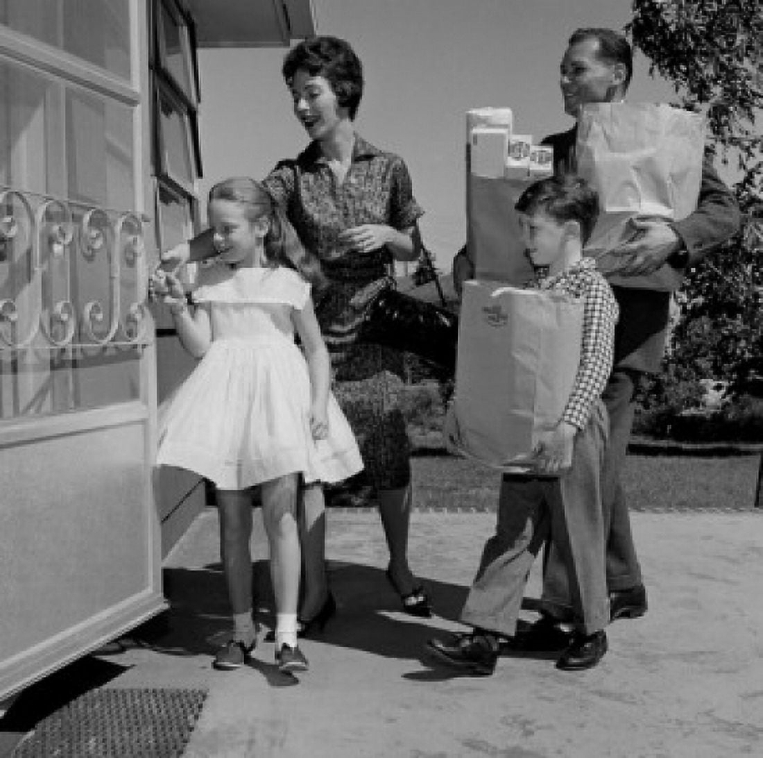 Parents and kids arriving home with shopping Canvas Art - (18 x 24)