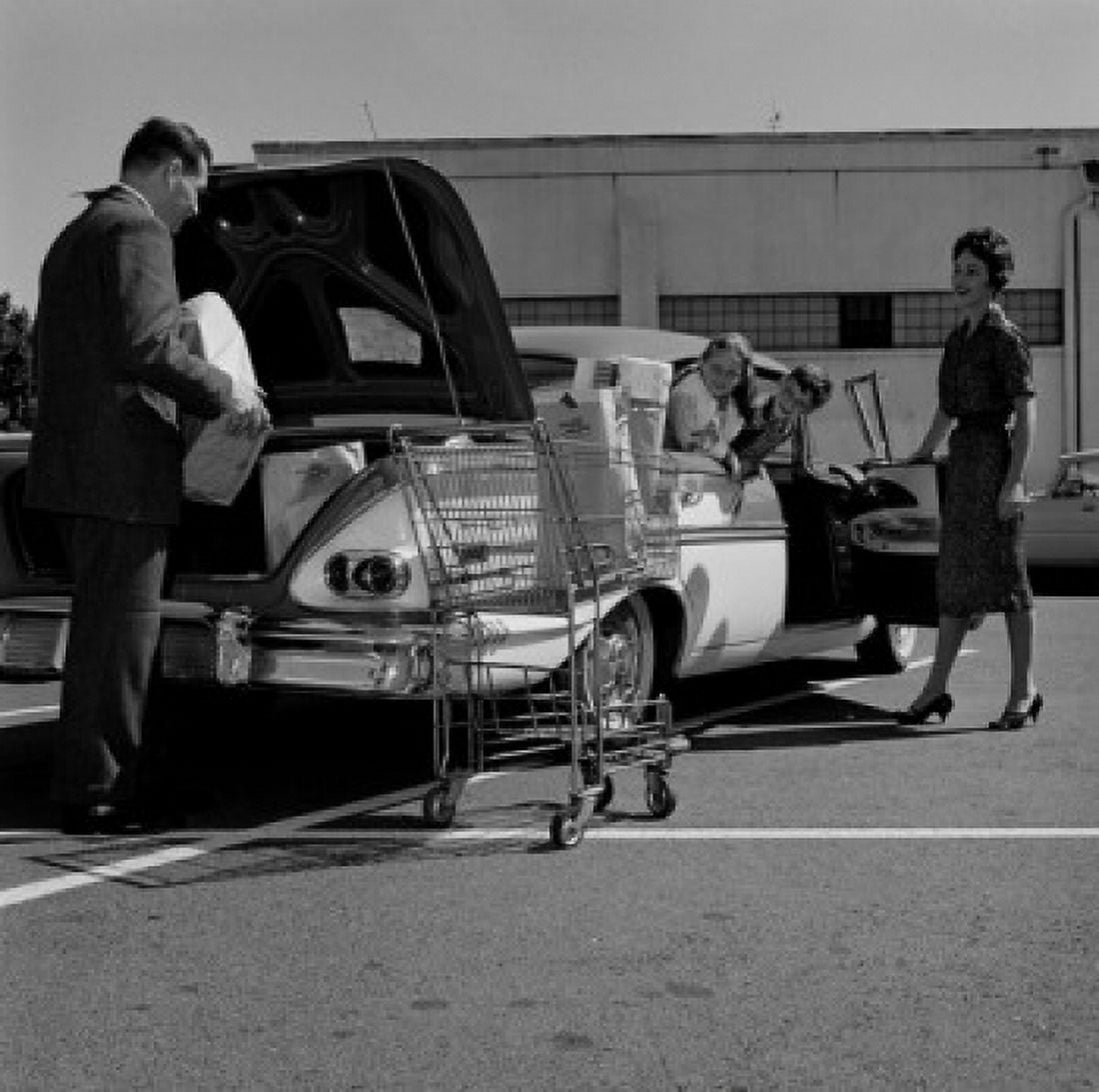 Parents and kids loading shopping bags into car trunk Canvas Art - (18 x 24)