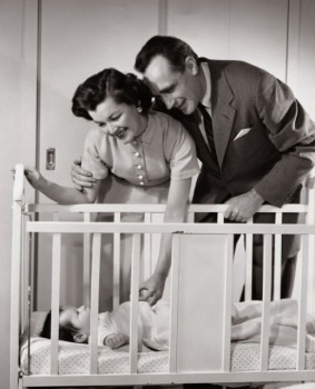 Parents looking at their baby lying in a crib Canvas Art - (24 x 36)