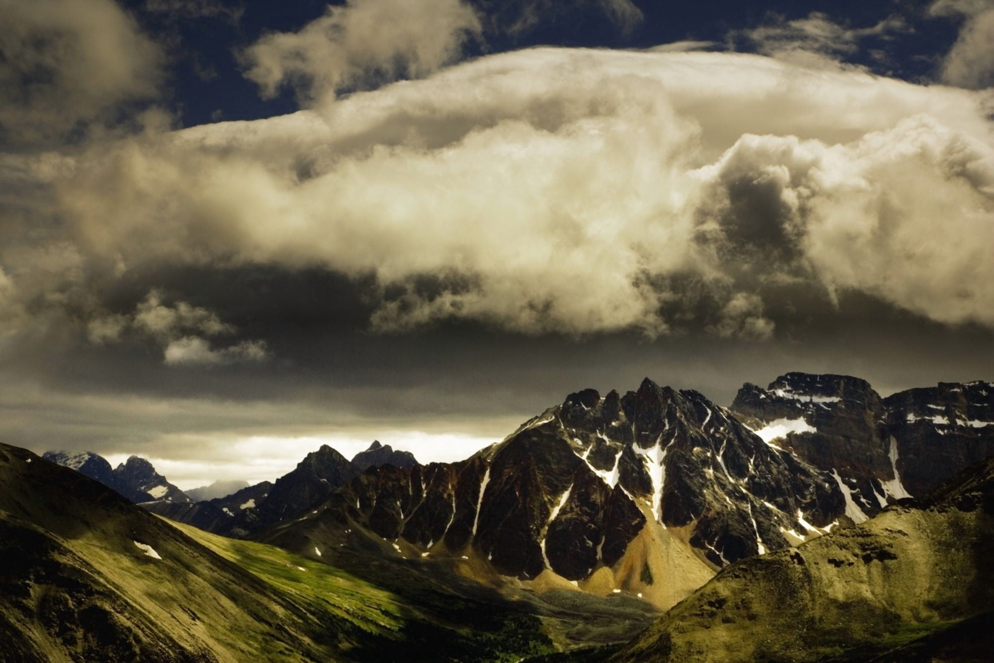 Patches Of Light Find Their Way Through Hovering Clouds Above Mountain Range Canvas Art - Darren Greenwood Design Pics (17 x 11)