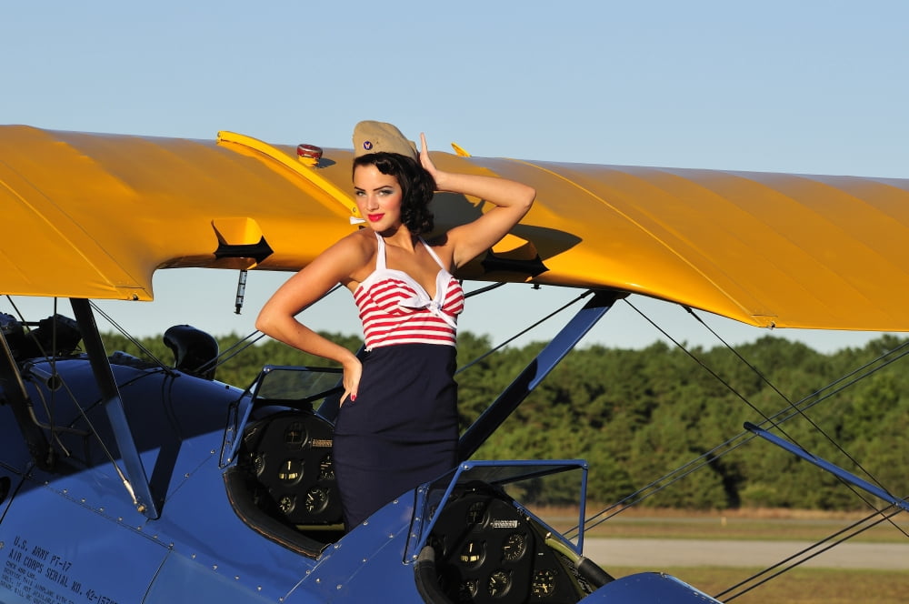 Patriotic pin-up girl standing inside the cockpit of a Stearman biplane Canvas Art - Christian KiefferStocktrek Images (18 x 12)