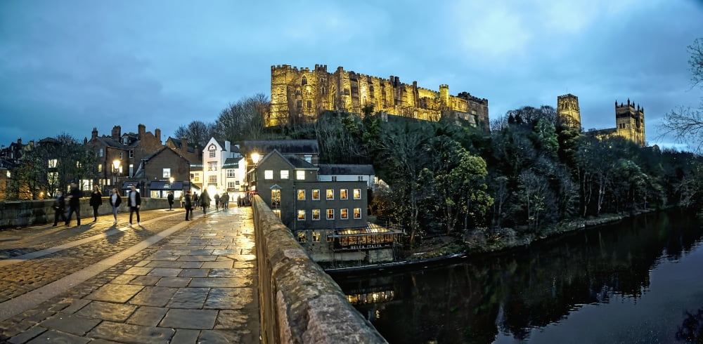Pedestrians walking on a walkway over a river at dusk with Durham Cathedral and Castle on a hilltop Durham England Canvas Art - John Short Design Pics (44 x 20)