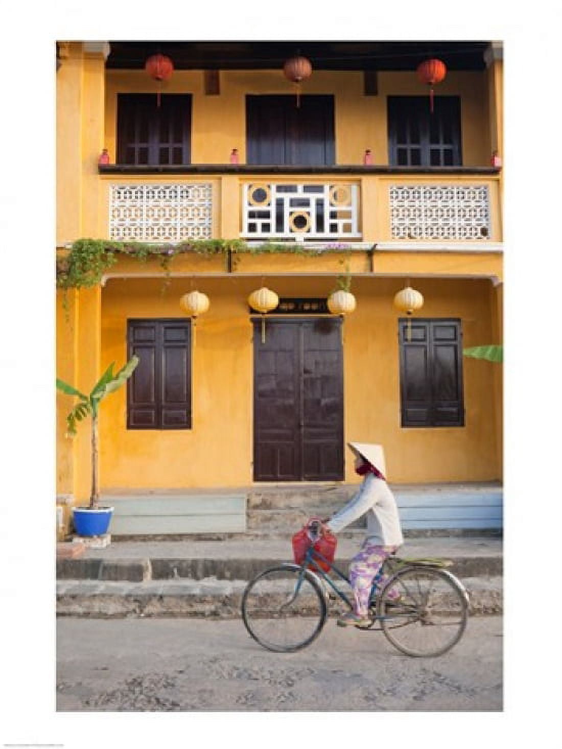 Person riding a bicycle in front of a cafe Hoi An Vietnam Canvas Art - (18 x 24)