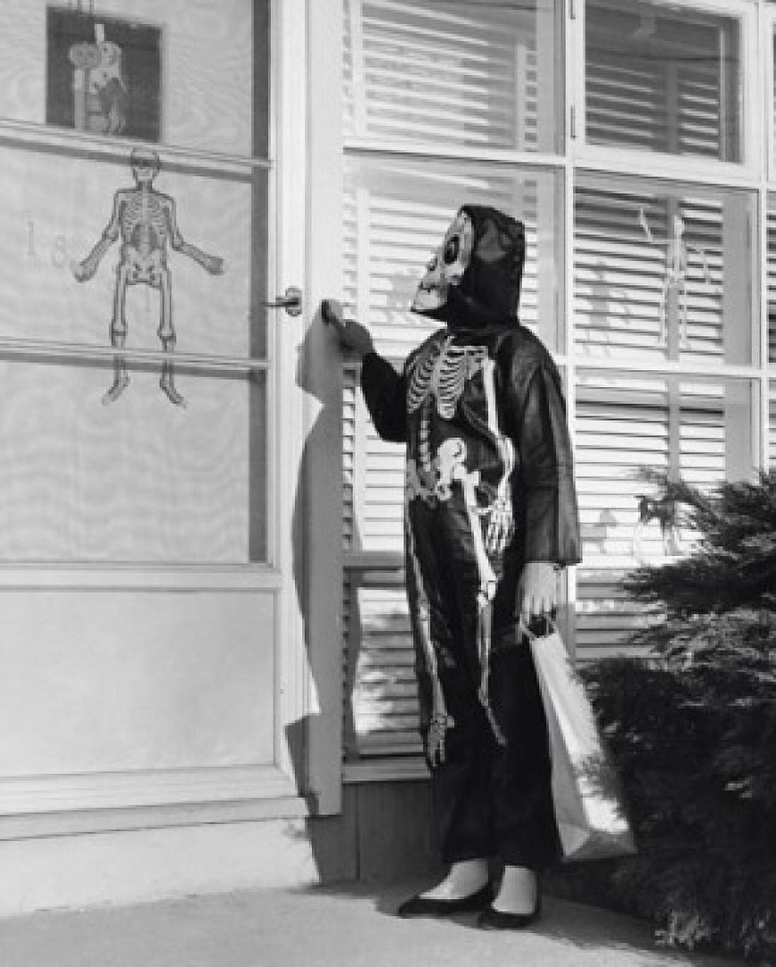 Person wearing a Halloween costume pressing the doorbell of a house Canvas Art - (18 x 24)