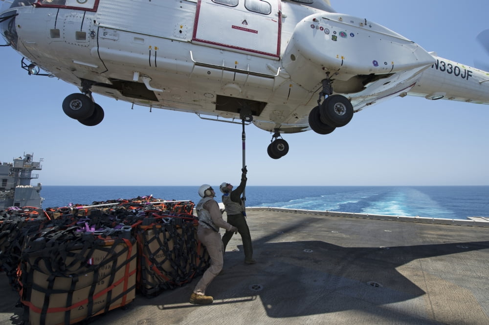 Personnel attach a cargo hook to an SA-330J Puma helicopter Canvas Art - Stocktrek Images (35 x 23)