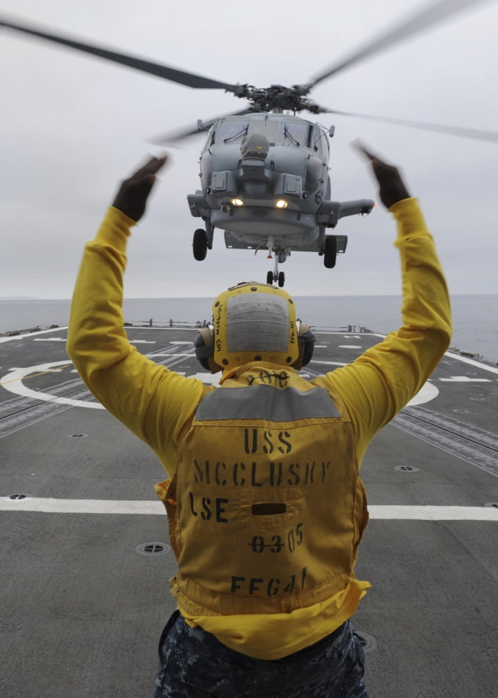 Petty Officer guides an SH-60R Sea Hawk helicopter onto the flight deck of USS McClusky Canvas Art - Stocktrek Images (24 x 34)