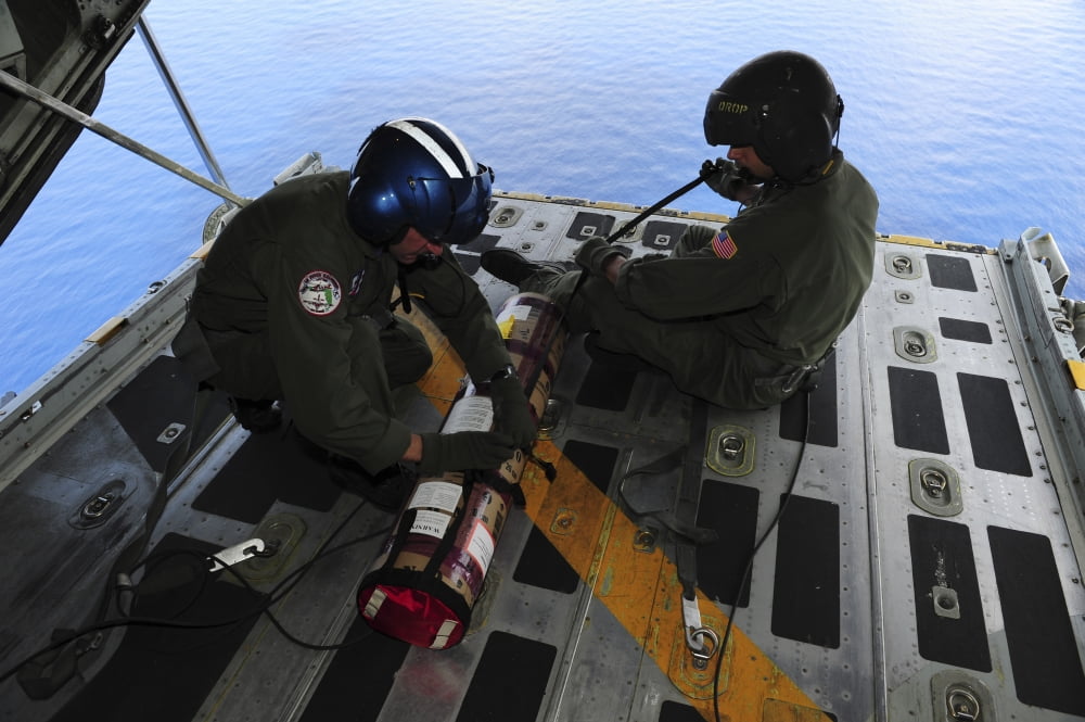 Petty Officers prepare to drop a satellite-enabled data marker buoy from the rear of a C-130 Hercules Canvas Art - Stocktrek Images (34 x 23)