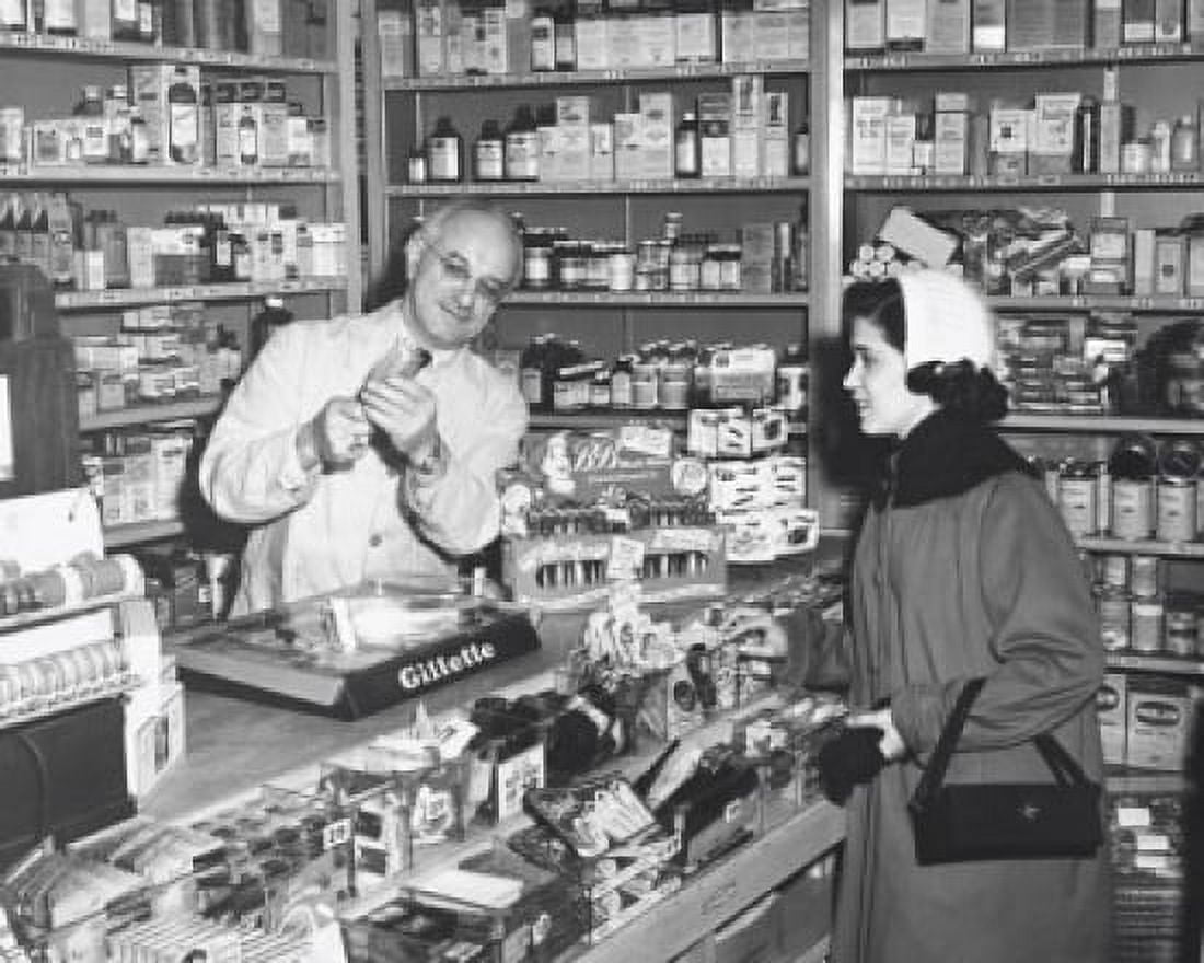 Pharmacist demonstrating a product to a young woman Canvas Art - (18 x 24)