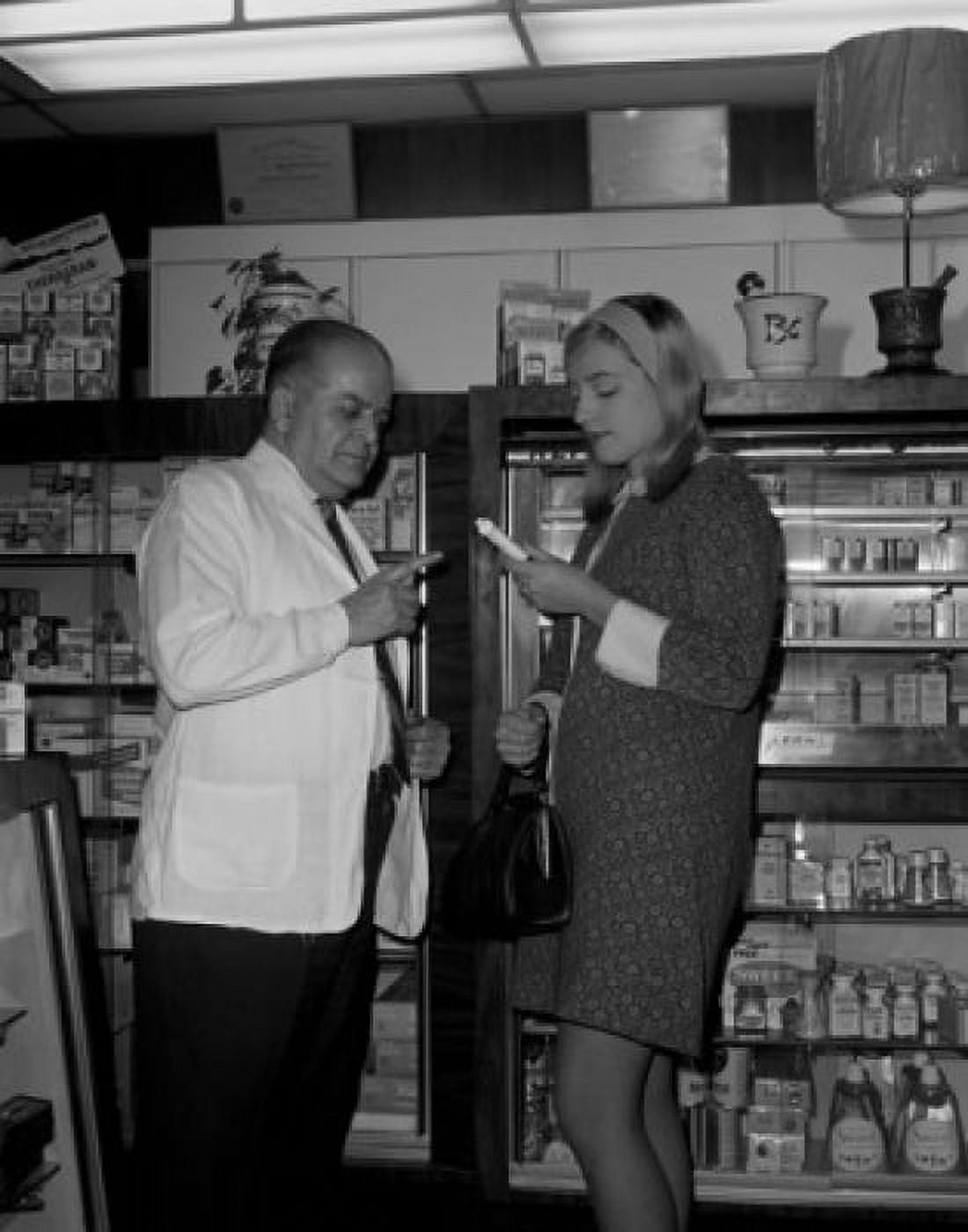 Pharmacist explaining to young woman Canvas Art - (24 x 36)