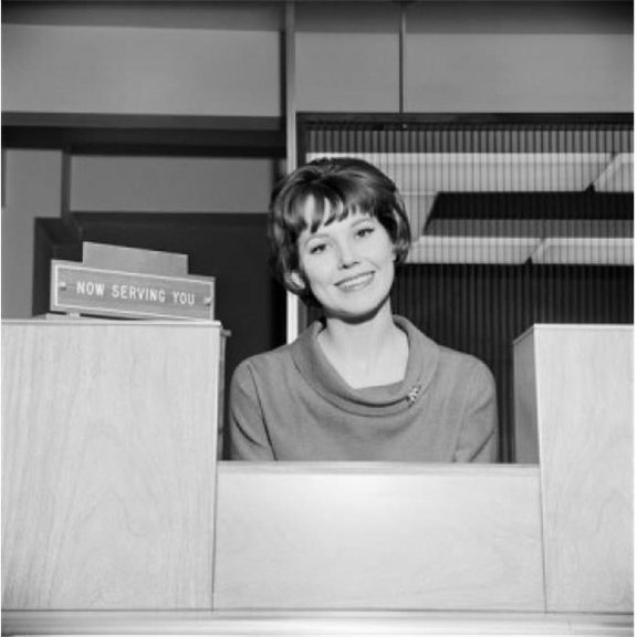 Portrait of Female Attendant Behind Counter Poster Print - 18 x 24 in.