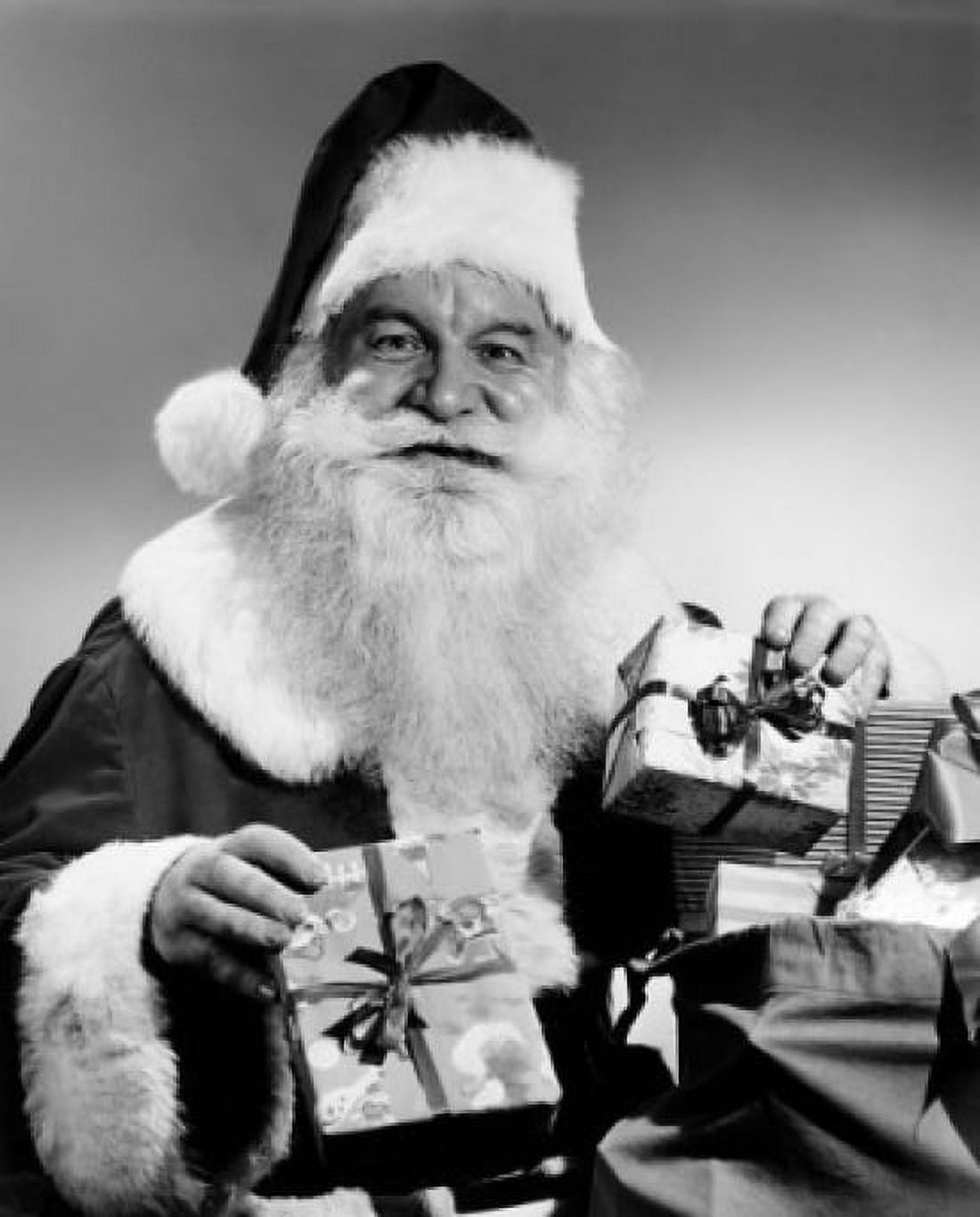 Portrait of Santa Claus holding Christmas presents and smiling Canvas Art - (18 x 24)