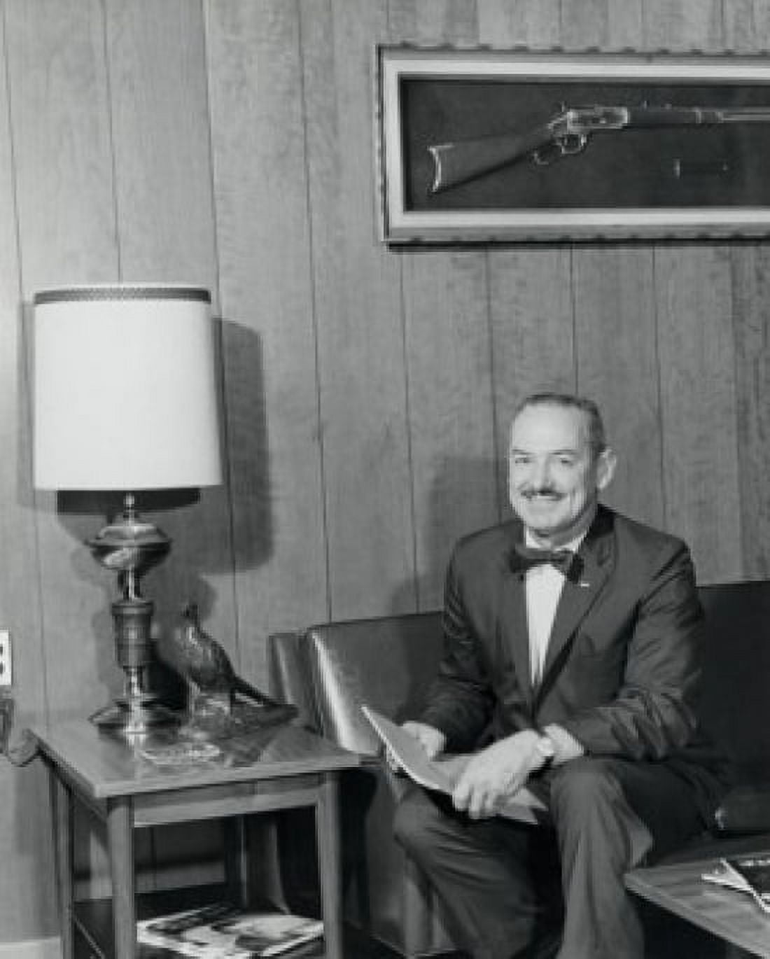 Portrait of a businessman sitting on a couch and holding a magazine Canvas Art - (24 x 36)