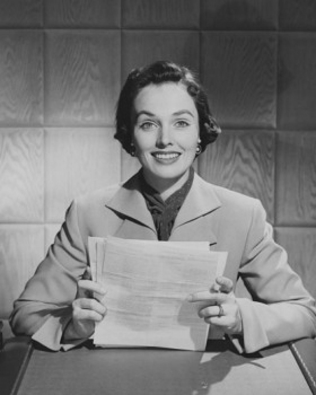 Portrait of a businesswoman sitting at a desk and holding documents in an office Canvas Art - (18 x 24)