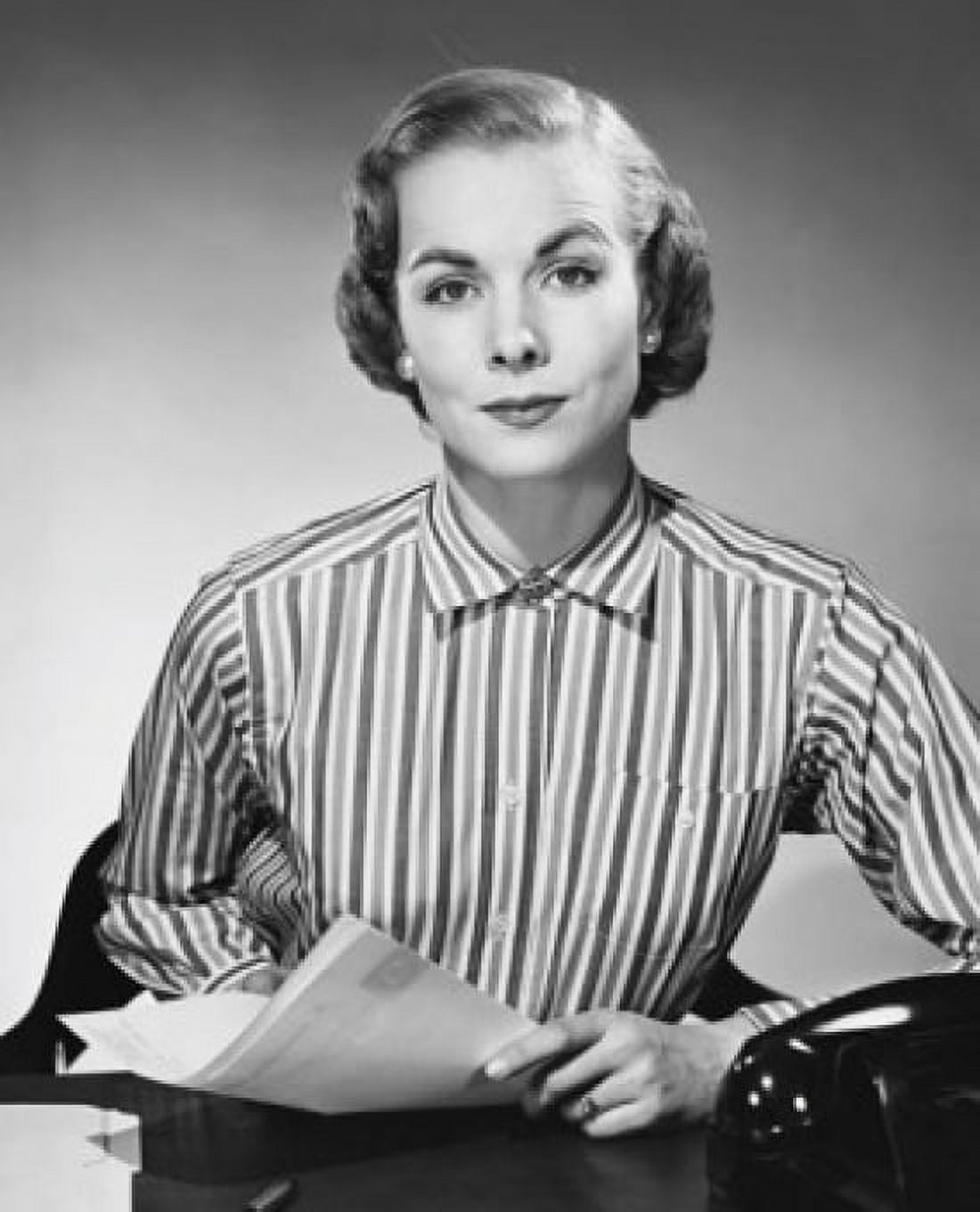 Portrait of a businesswoman sitting at a desk and holding documents in an office Canvas Art - (24 x 36)