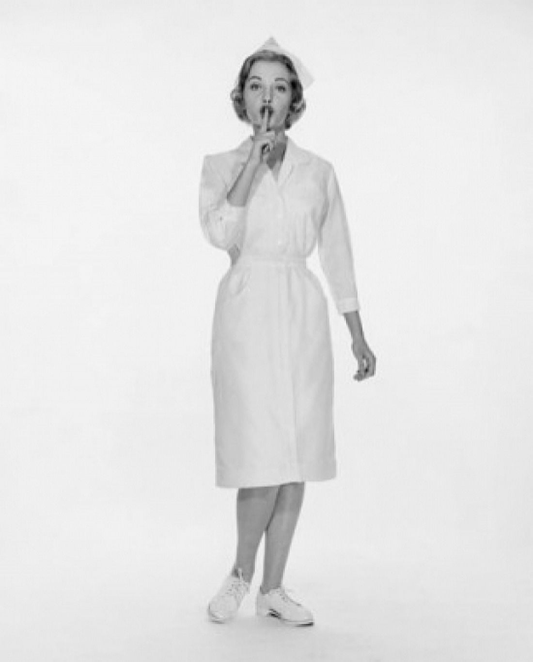 Portrait of a female nurse standing with her finger on her lips Canvas Art - (24 x 36)
