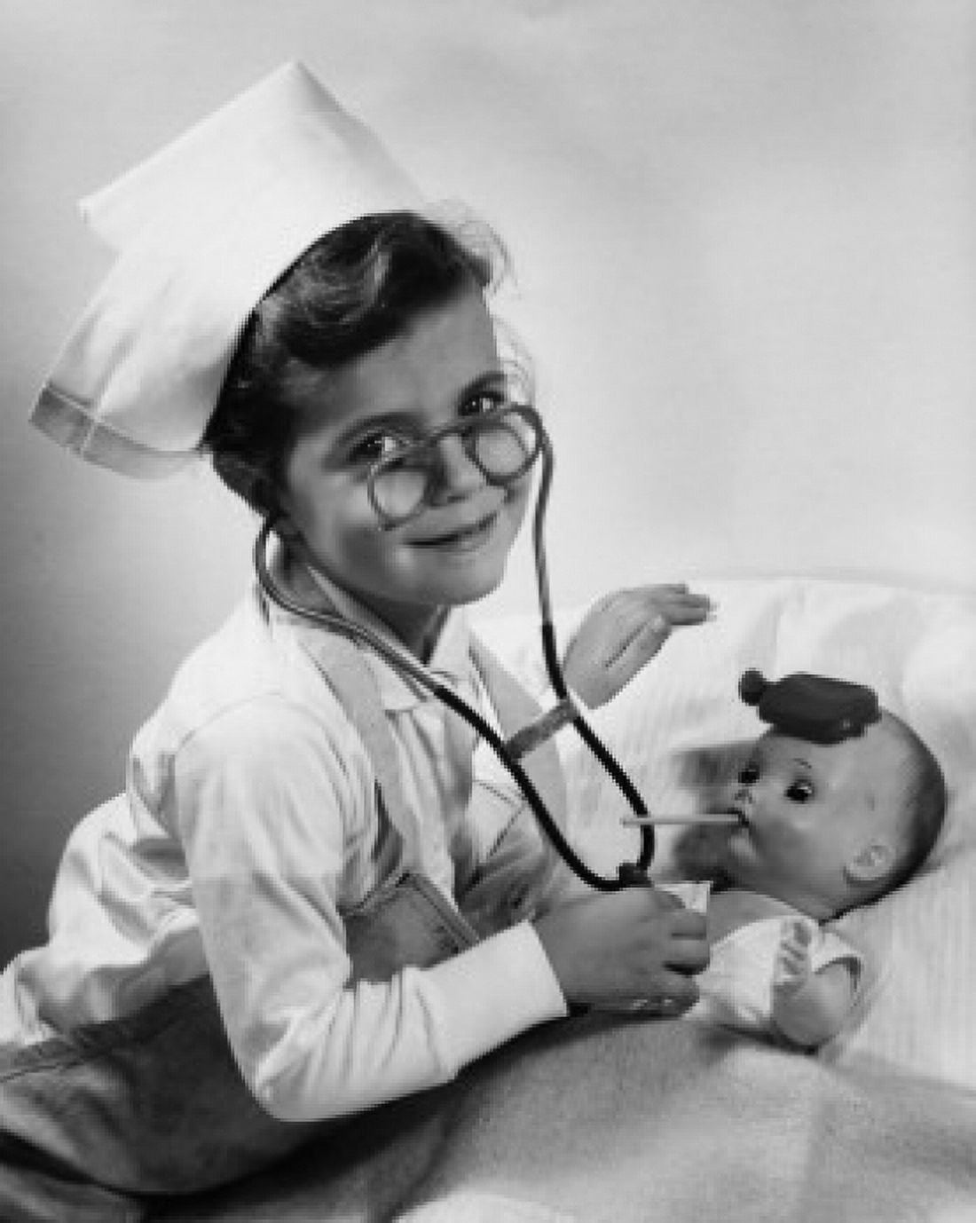 Portrait of a girl dressed as a nurse playing with her doll Canvas Art - (24 x 36)