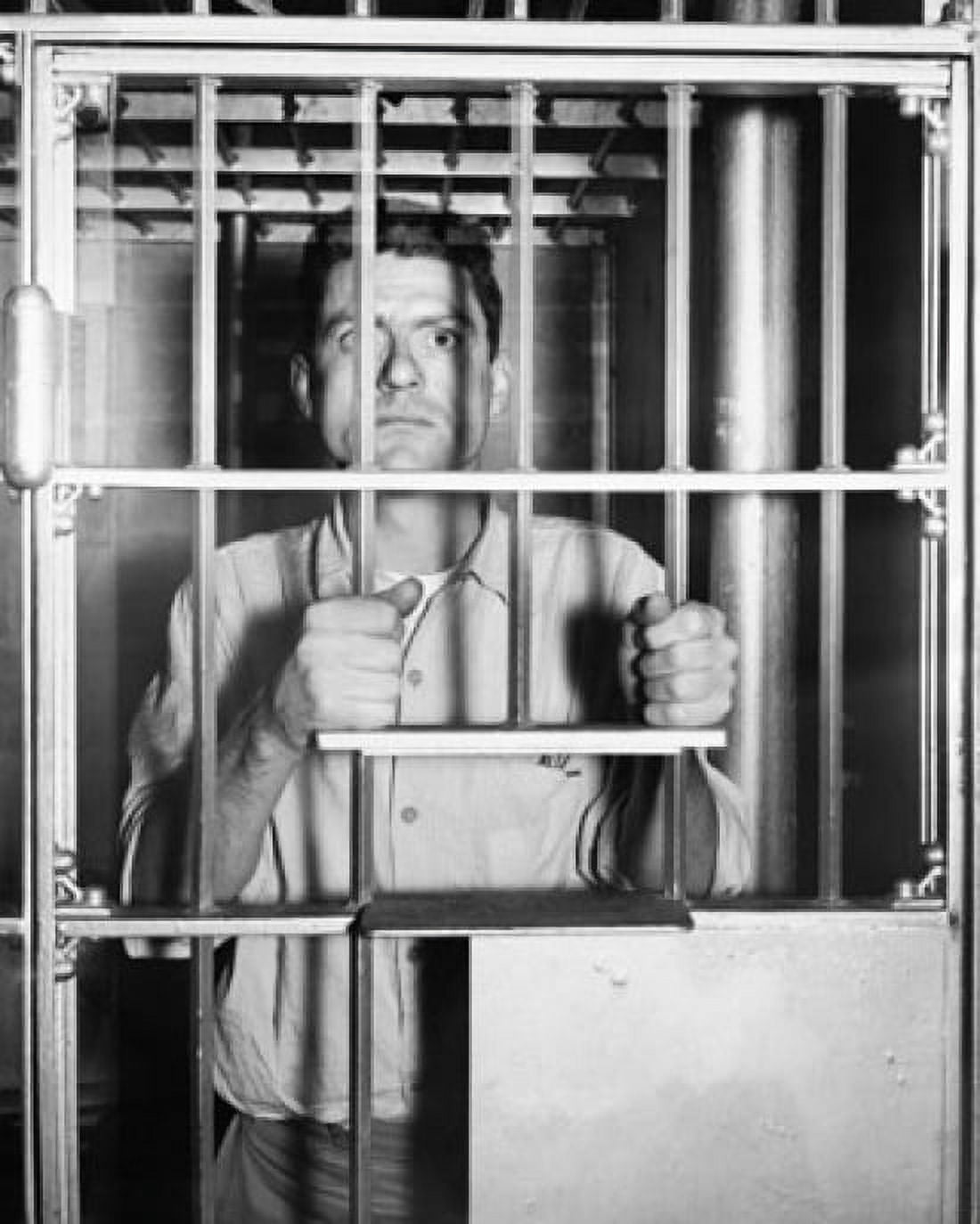 Portrait of a mid adult man standing behind prison bars Canvas Art - (24 x 36)