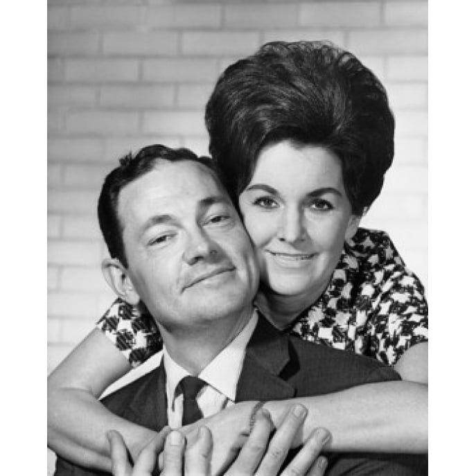 Portrait of a mid adult woman embracing a mid adult man from behind ...