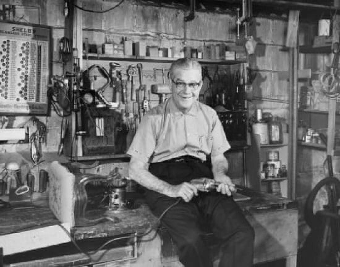 Portrait of a senior man sitting in a workshop and holding a drill Canvas Art - (24 x 36)